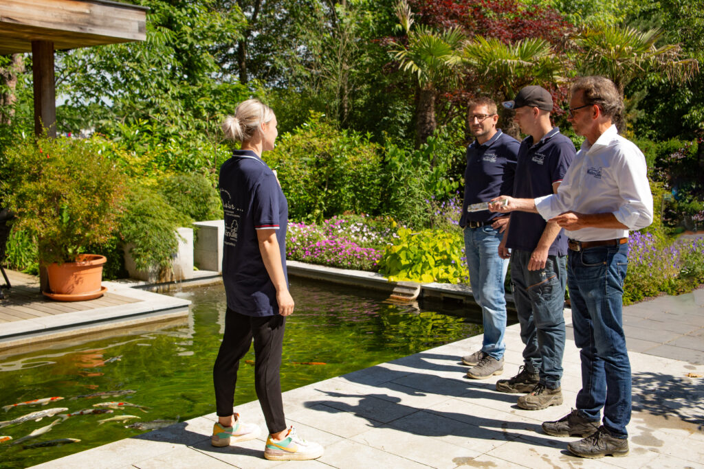 Mitarbeiter von Weißmüller Garten & Landschaftsbau vor einem Koiteich